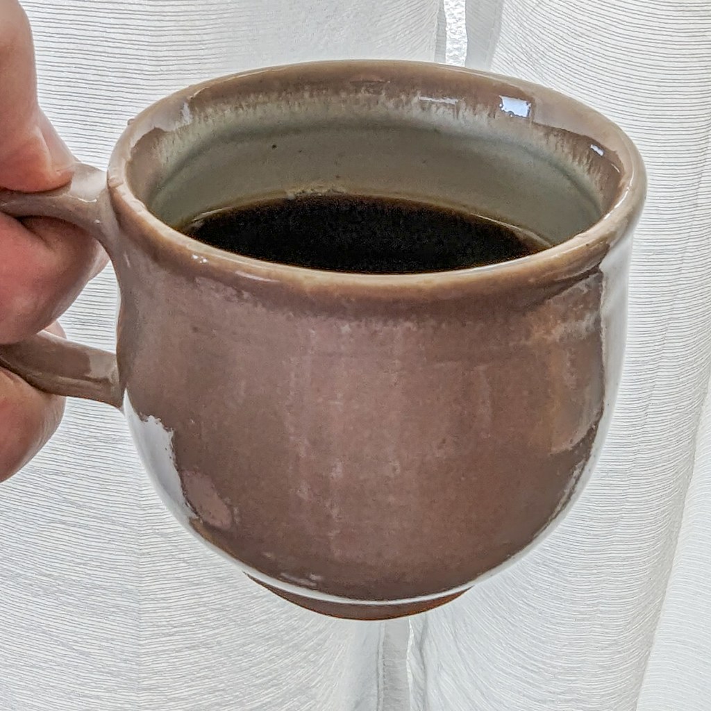A pinkish, rounded coffee cup reminiscent of Hagi ware.