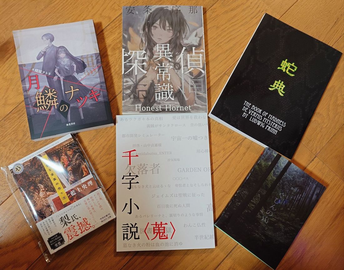 Six Japanese books arranges on a hardwood floor.