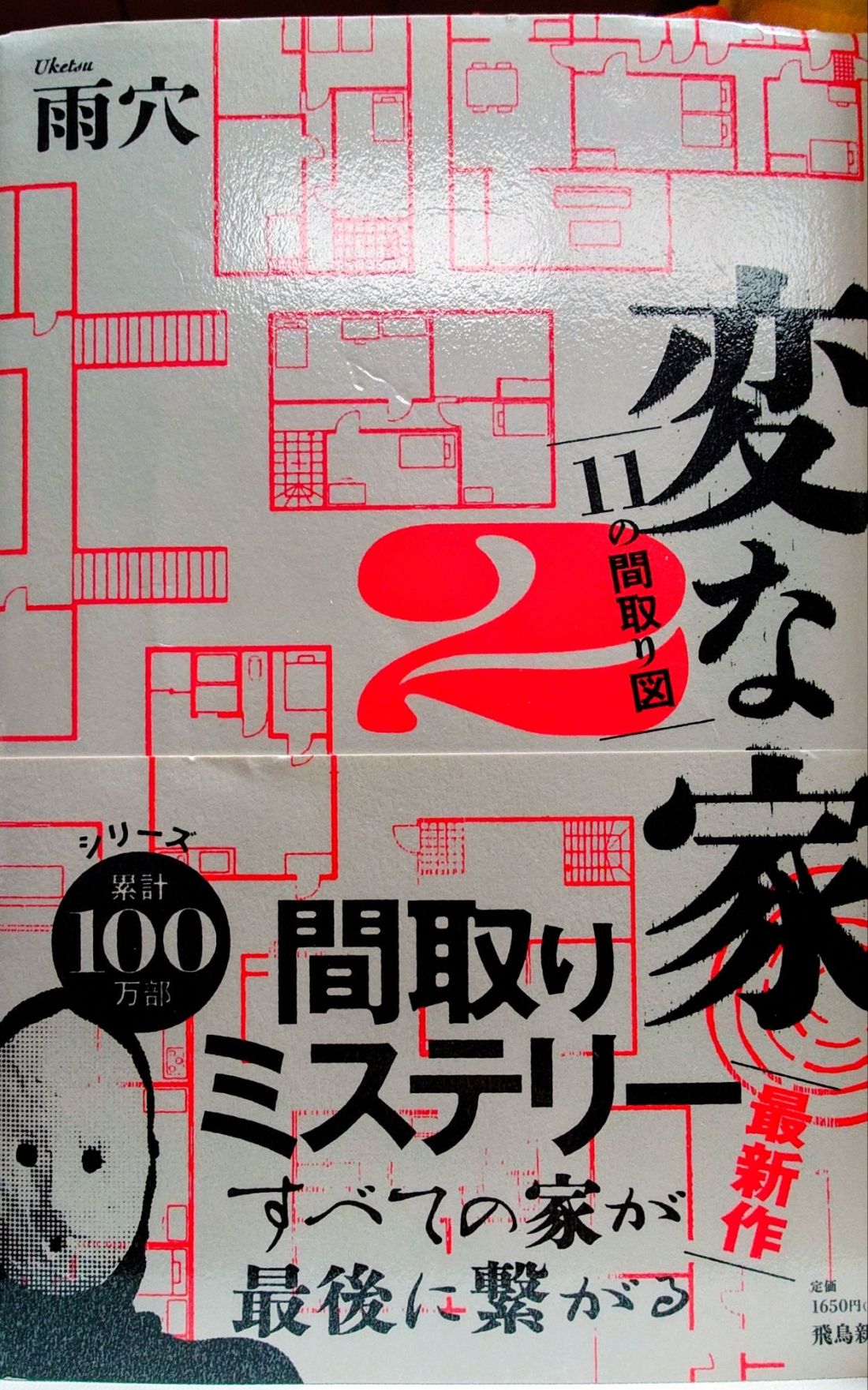 A gray cover with red line drawings of building plans. It has a picture of Uketsu in one corner.
